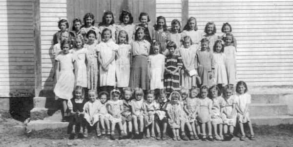 511: Group of 39 young ladies. (circa 1950) [courtesy of Lorna Richardson] ** also see 512 &amp;amp; 513 **  Standing in back row (top step) left-to-right, Imelda Ryan, Annie Norman, Marg Norman,  Marie Ryan, Angela Ryan, Gwen Carroll, Marie Counsel, Teresa Whelan, Beth Lambe, Kathleen Barry,  Teresa Norman; standing in second row from back (second step), Madonna McCarthy, Babe Ennis,  Mary Finn, Noreen Ryan, Mary Ennis, Madonna Whelan, Kathleen Lambe, unidentified,  Gert Ryan, Teresa Kerrivan, Lorraine Kerrivan, Anne Counsel; standing on first step, Mary Reddy;  sitting on first step left-to-right, ? Ennis, unidentified, Sheila Ryan (wearing bonnet),  unidentified (with white bow), unidentified, ? Ennis, Irene Webber, unidentified (dark dress),  unidentified (wearing white head covering), unidentified, Hilda Whelan, unidentified,  Rita Whelan, unidentified, Bernardine Whelan. ** more details below **  - Kathleen Barry (of Thomas Barry &amp;amp; Anne Dollimont)  - Gwen Carroll (of Michael Carroll &amp;amp; Josephine Barry)  - Anne Counsel (of Michael Counsel &amp;amp; Mary Anne Barry)  - Marie Counsel (of Michael Counsel &amp;amp; Mary Anne Barry)  - Babe Ennis (of Vincent Ennis &amp;amp; Mary Carroll)  - Mary Ennis (of Vincent Ennis &amp;amp; Mary Carroll)  - Mary Finn (of Patrick Finn &amp;amp; Helena Hayward)  - Lorraine Kerrivan (of James Kerrivan &amp;amp; Josephine Norman)  - Teresa Kerrivan (of Peter Kerrivan &amp;amp; Cecilia Cheeseman)  - Beth Lambe (of James Lambe &amp;amp; Catherine Rodgers)  - Kathleen Lambe (of James Lambe &amp;amp; Catherine Rodgers)  - Madonna McCarthy (of James McCarthy &amp;amp; Mary Ellen Barry)  - Annie Norman (of John Norman &amp;amp; Mary Farget)  - Marg Norman (of Charles Norman &amp;amp; Elizabeth Anne Barry)  - Teresa Norman (of Peter Norman &amp;amp; Margaret Norman)  - Mary Reddy (of Michael Reddy &amp;amp; Elizabeth Moore)  - Angela Ryan (of Michael Ryan &amp;amp; Petronella Whelan)  - Gert Ryan (of Jeremiah Ryan &amp;amp; Josephine Lambe)  - Imelda Ryan (of Jeremiah Ryan &amp;amp; Josephine Lambe)  - Marie Ryan (of Joseph Ryan &amp;amp; Ursula Barry)  - Noreen Ryan (of Albert Ryan &amp;amp; Catherine Nolan)  - Sheila Ryan (of Albert Ryan &amp;amp; Catherine Nolan)  - Irene Webber (of William Webber &amp;amp; Anne Counsel)  - Bernardine Whelan (of Leo Whelan &amp;amp; Elizabeth Bishop)  - Hilda Whelan (of Leo Whelan &amp;amp; Elizabeth Bishop)  - Madonna Whelan (of Leo Whelan &amp;amp; Elizabeth Bishop)  - Rita Whelan (of Leo Whelan &amp;amp; Elizabeth Bishop)  - Teresa Whelan (of Leo Whelan &amp;amp; Elizabeth Bishop)